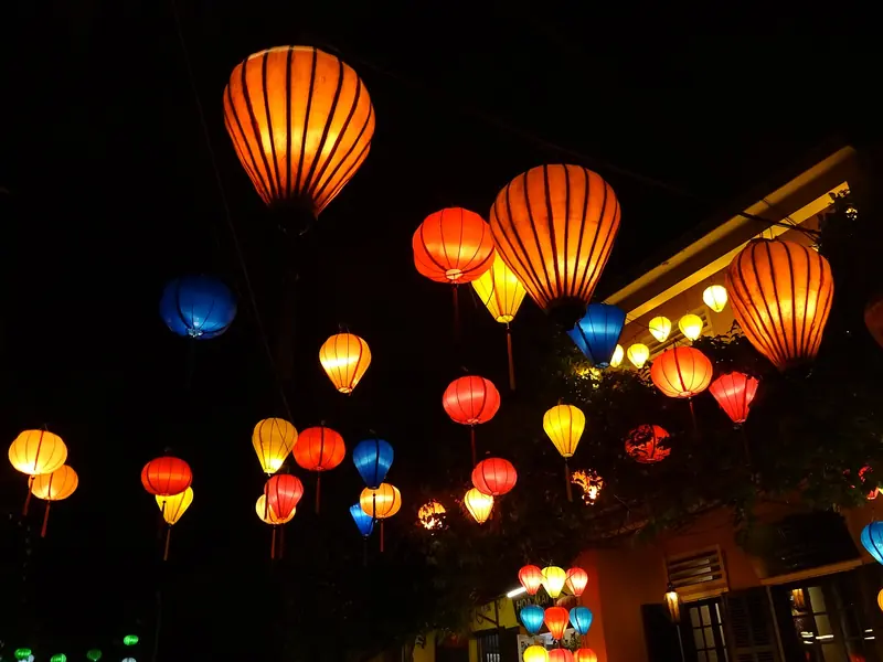 Glowing silk lanterns against the night sky in Hội An