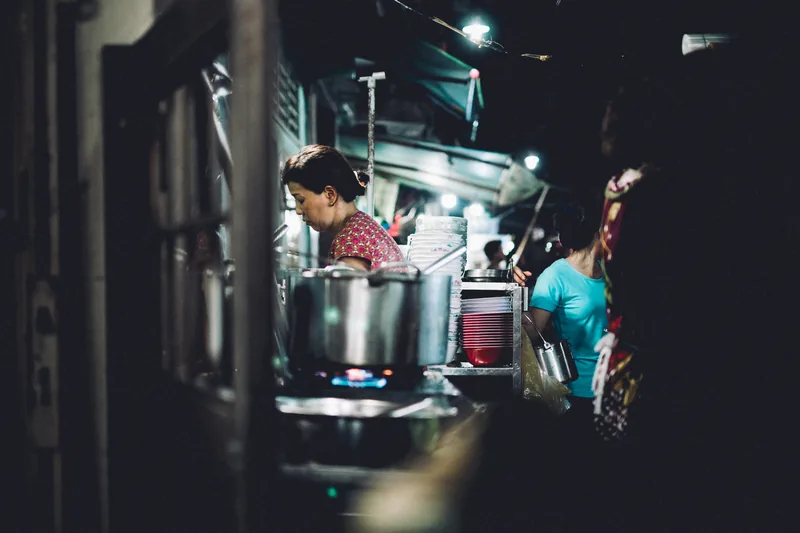 Street food stalls glowing under warm lights at night